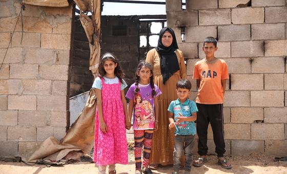 A Palestinian family stands outside their home in southern Hebron, in the West Bank, that was burned in a settler attack.